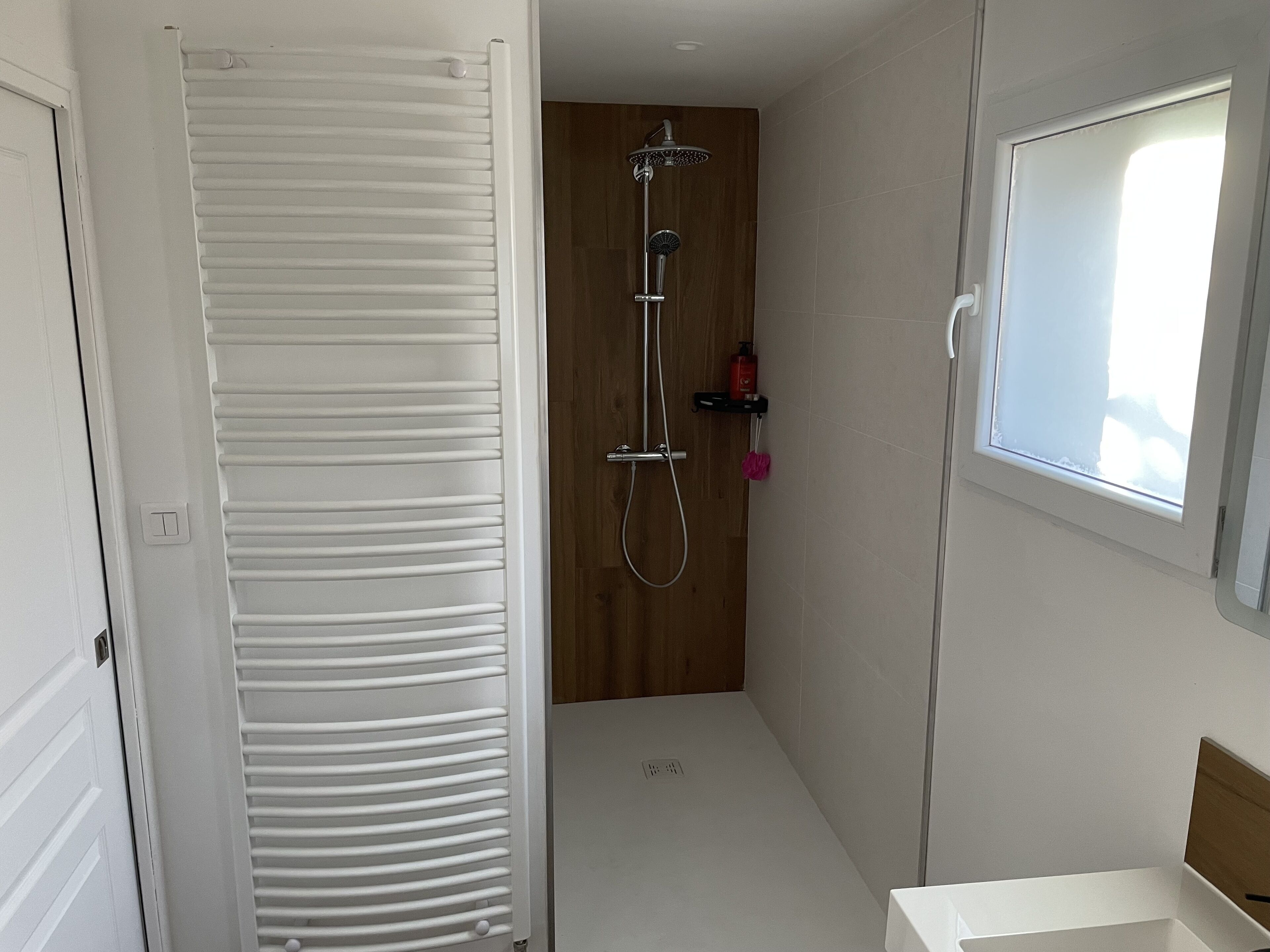 Un bagno moderno e piccolo, con doccia, toilette e lavandino.