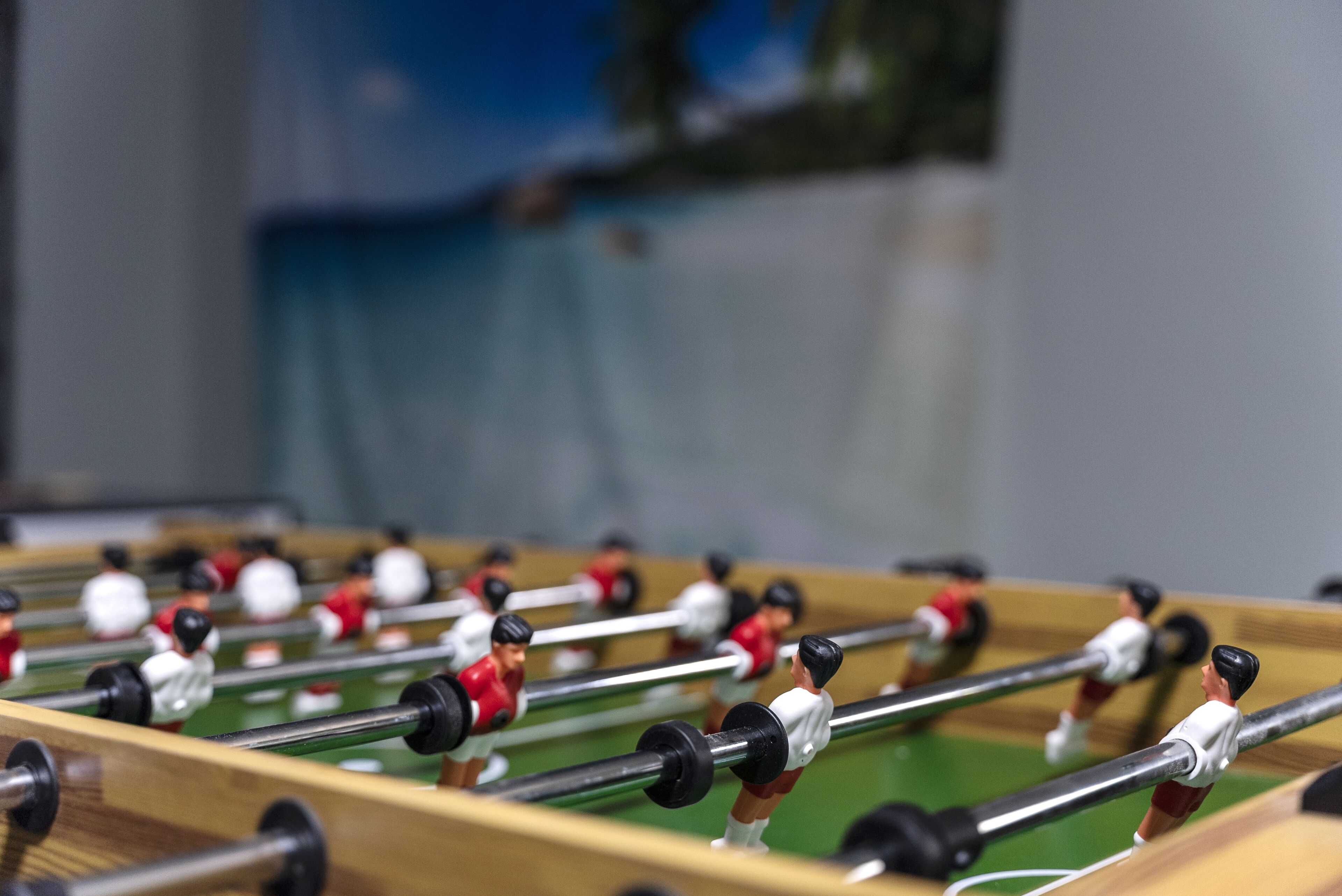 Una mesa de fútbolín con varios jugadores y una pelota.