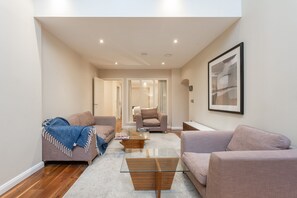Relax in this stylish living room with a sofa, coffee table, and artwork on the wall.