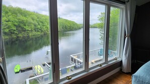 A room with a large window overlooking a lake and dock. - SECLUDED WATERFRONT HOME WITH ROOM FOR ALL (Hopkinton)