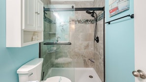 A bathroom with a glass-enclosed shower, a toilet, and a sink. - Dolphin Kisses @ Beach Harbor Condos. "B Bldg" - New in 2024. Linens Included! (Carolina Beach)