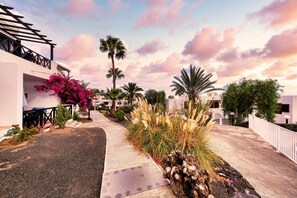 Stroll through a tranquil neighborhood lined with homes featuring balconies and lush tropical gardens.