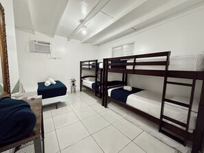 A dormitory room with bunk beds, a small desk, a chair, a mirror, and a potted plant. - Vacation House with Private Pool| El Rancho Vacation House (Cabo Rojo)