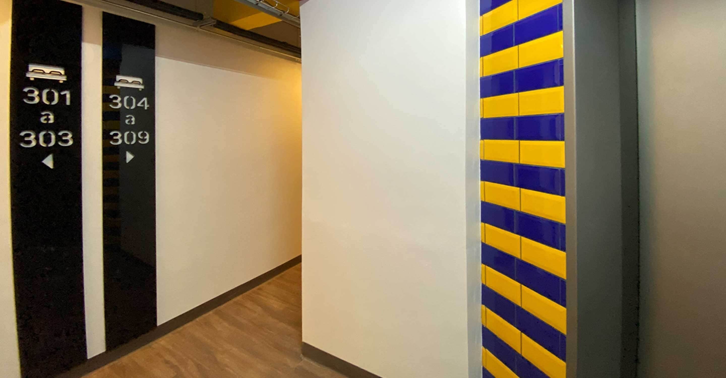 A hotel corridor with room numbers 301 to 309 on the left wall.
