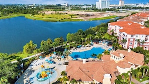 A resort with a swimming pool, lounge area, and a water park. - Vista Cay Luxury Rhapsody. Walk to Epic Universe and the OCCC (Orlando)