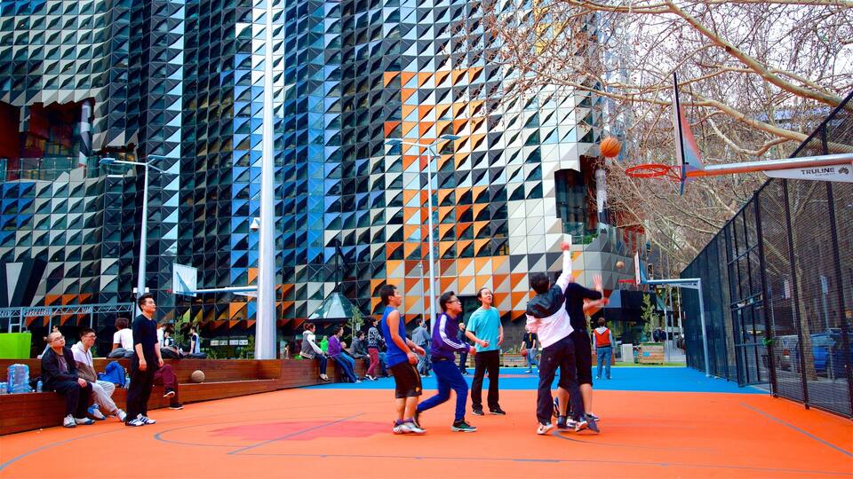 Una cancha de baloncesto con un edificio moderno al fondo.