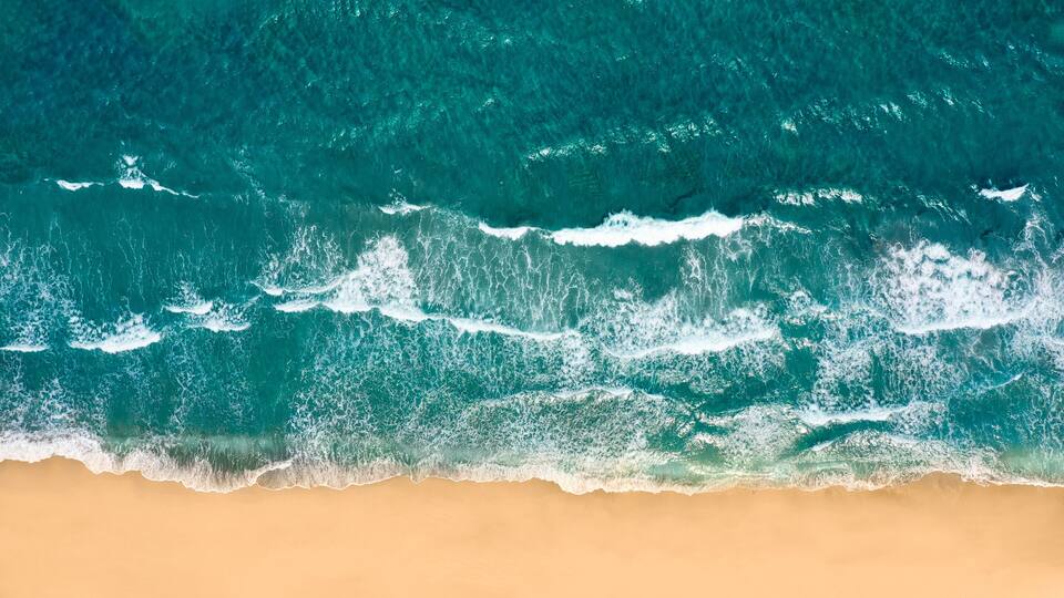 A beach with waves crashing onto the shore.
