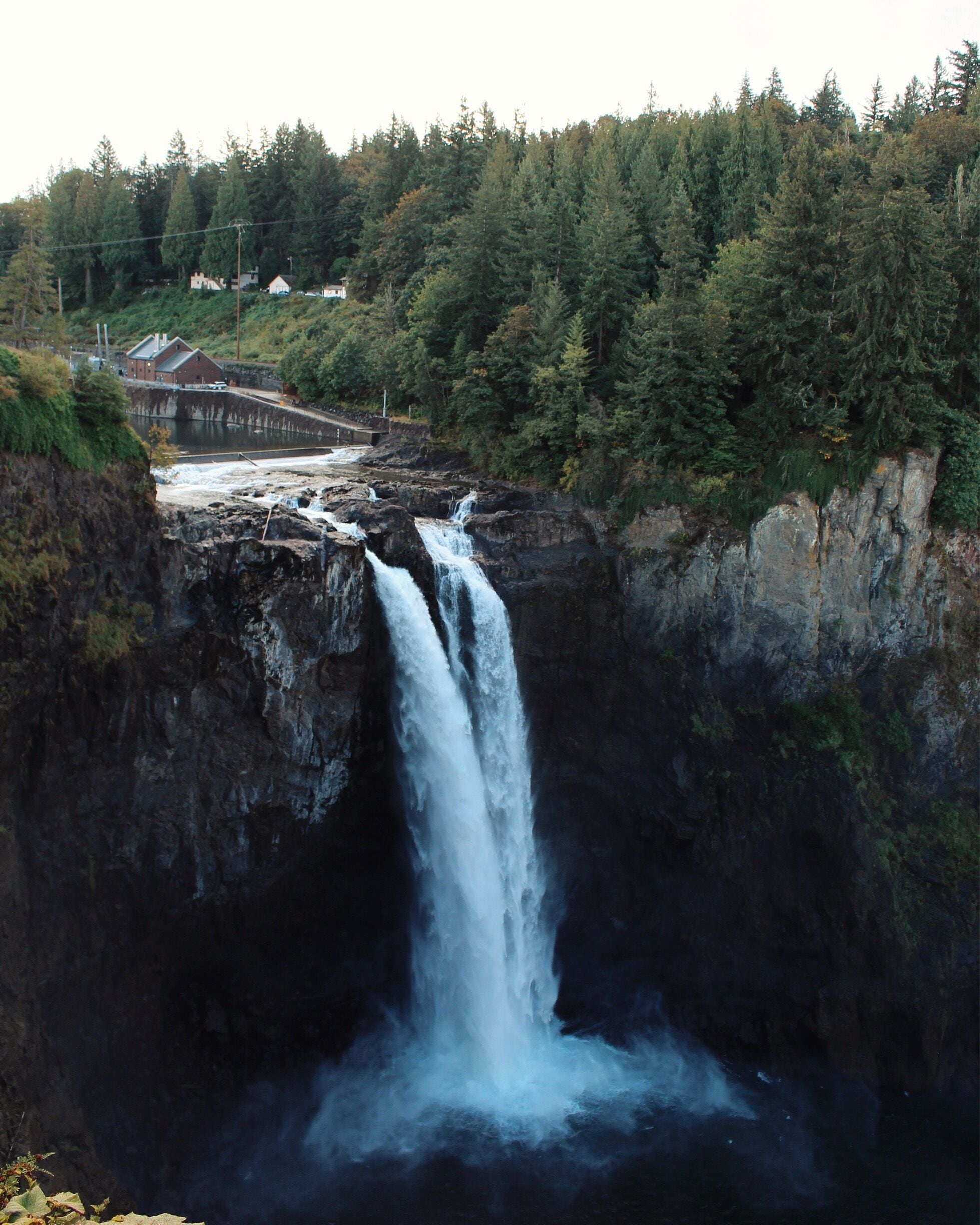 A waterfall cascading down a rocky cliff surrounded by dense forest.
