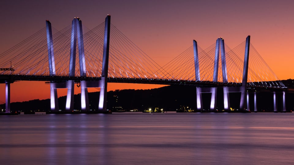 A bridge with multiple towers and cables against a twilight sky.