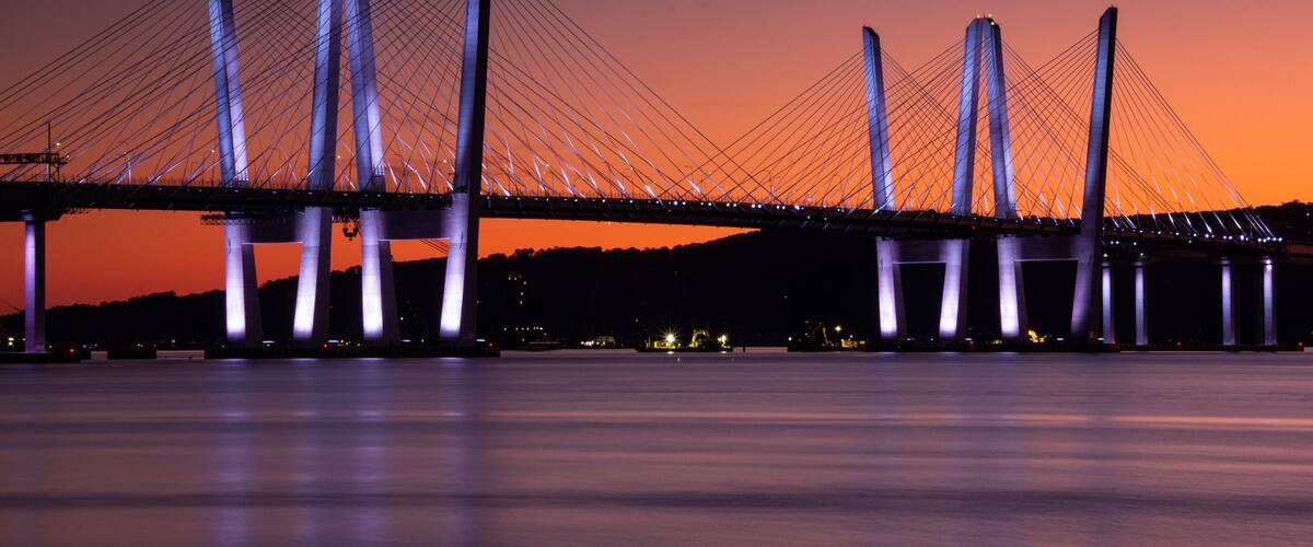 A bridge with multiple towers and cables against a twilight sky.