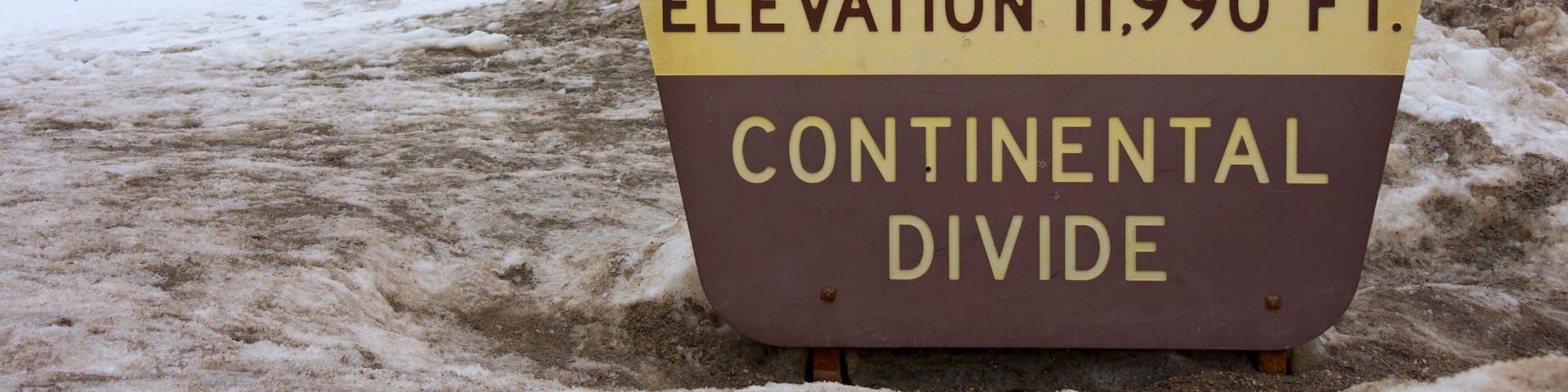 Sign marking Loveland Pass Continental Divide in Colorado Rocky Mountains with snow covered peaks in the background