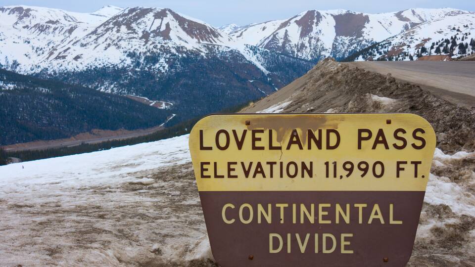 A sign indicating the Loveland Pass elevation at 11,990 feet and the continental divide.
