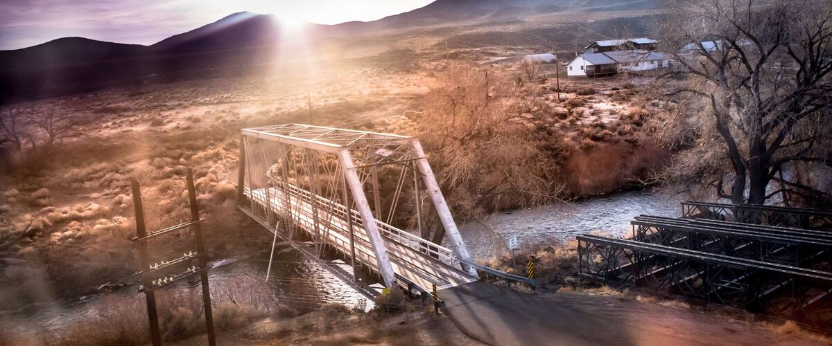 Bridge over the Truckee River at sunrise, Fernley, NV. Sun breaking over mountains.