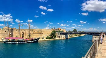 Un’antica fortezza, un’imponente nave a vela ormeggiata nel porto, e un ponte che collega due aree di terra.