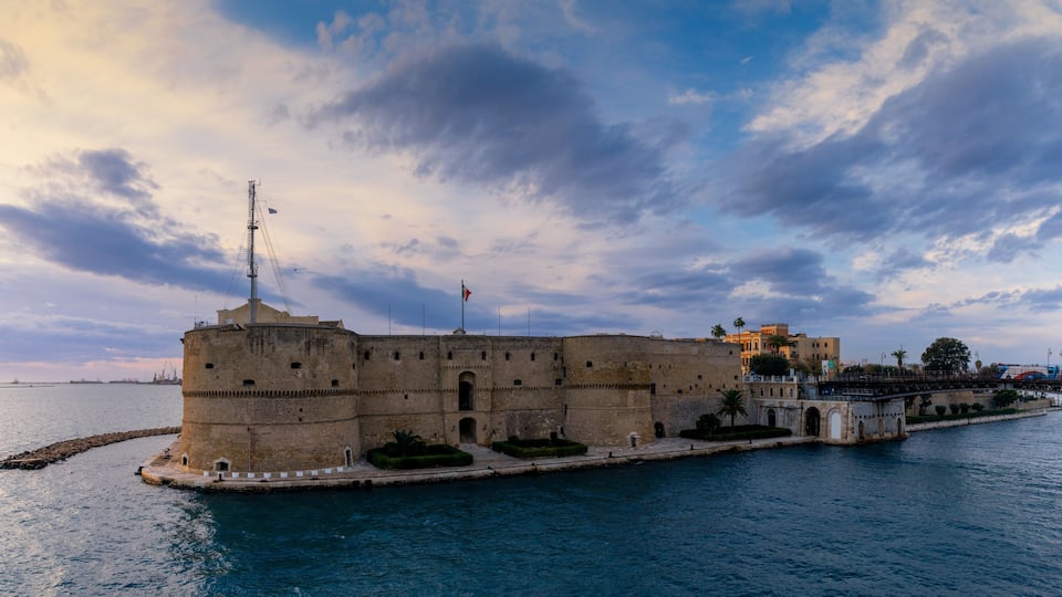 A historic fortification by the sea with a clear sky and calm waters.