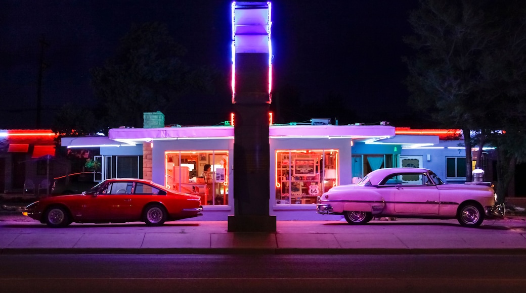 Tucumcari, New Mexico, USA. Famous Blue Swallow Motel on Route 66 at twilight with old cars parked in front and neon sign brightly lit. Property released
