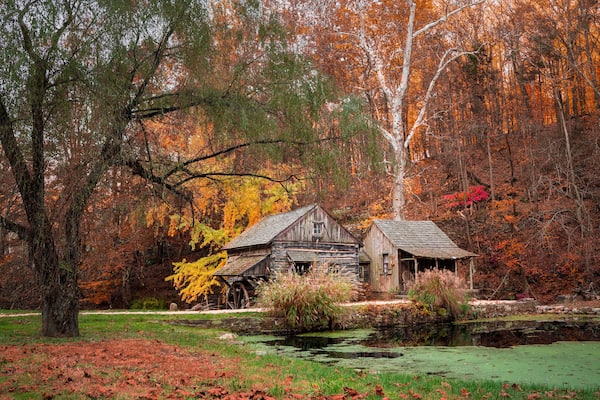 Beautiful autumn scene at Cuttalossa barn mill in Bucks County Pennsylvania with colorful fall foliage.