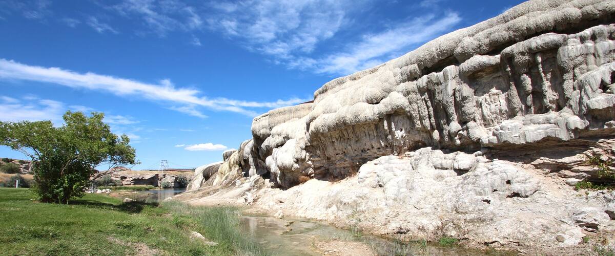A river flowing through a rocky landscape with a bridge in the distance.