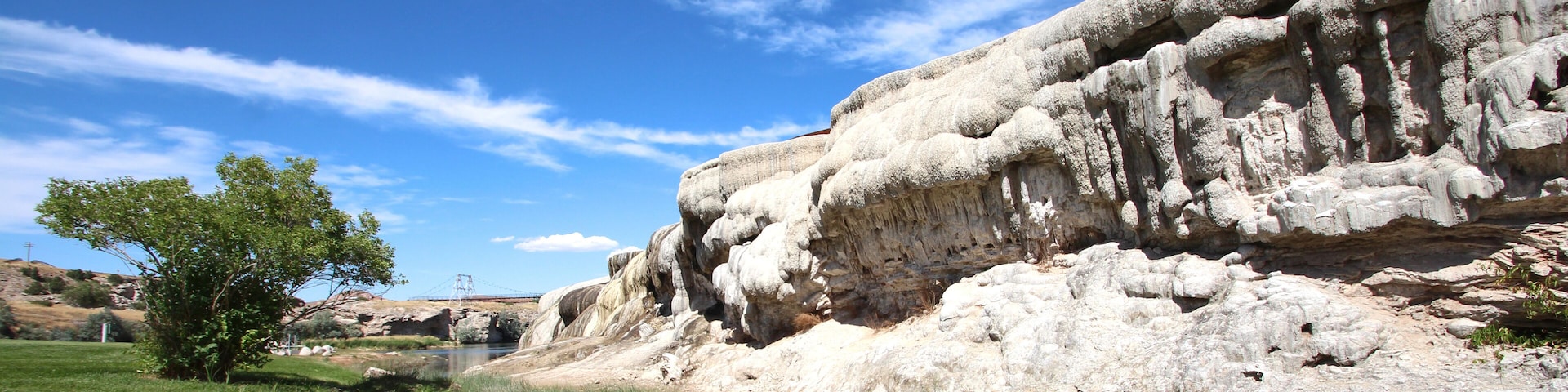 A river flowing through a rocky landscape with a bridge in the distance.