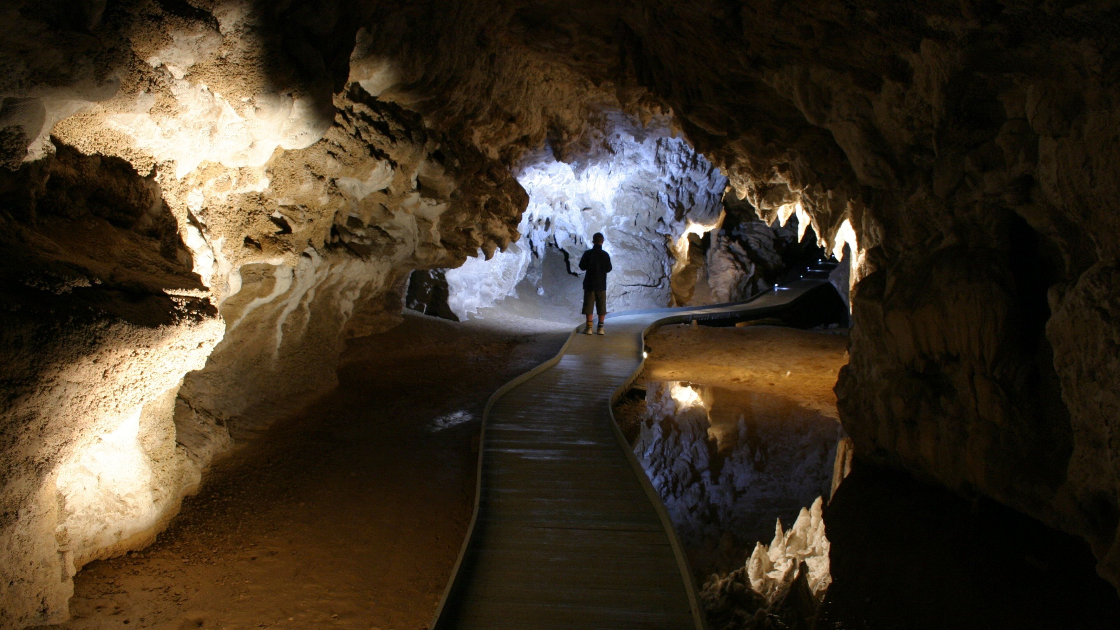 Una cueva con un pasillo de madera que conduce a una abertura luminosa.