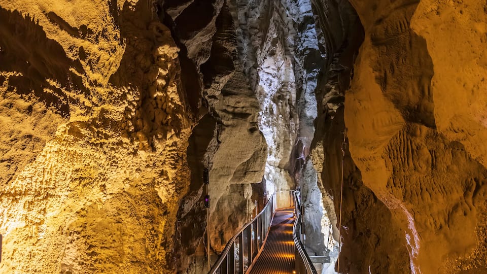 New Zealand, Oceania, North Island, Waitomo Caves, Ruakuri Cave, Narrow walkway and limestone formations in cave