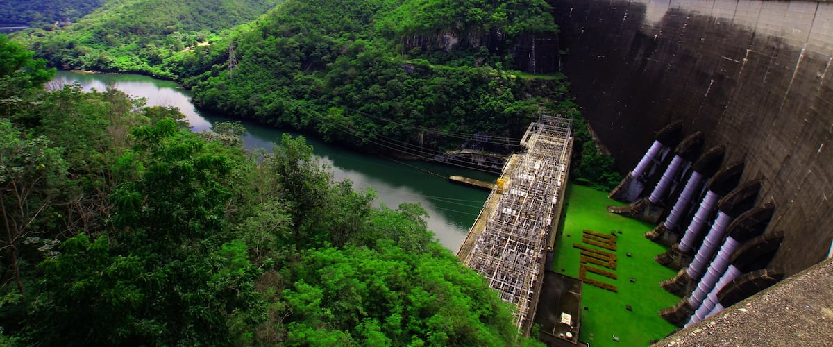 A hydroelectric dam with a river flowing through a lush valley.