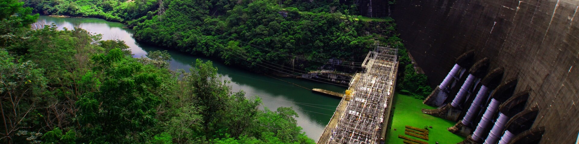 A hydroelectric dam with a river flowing through a lush valley.
