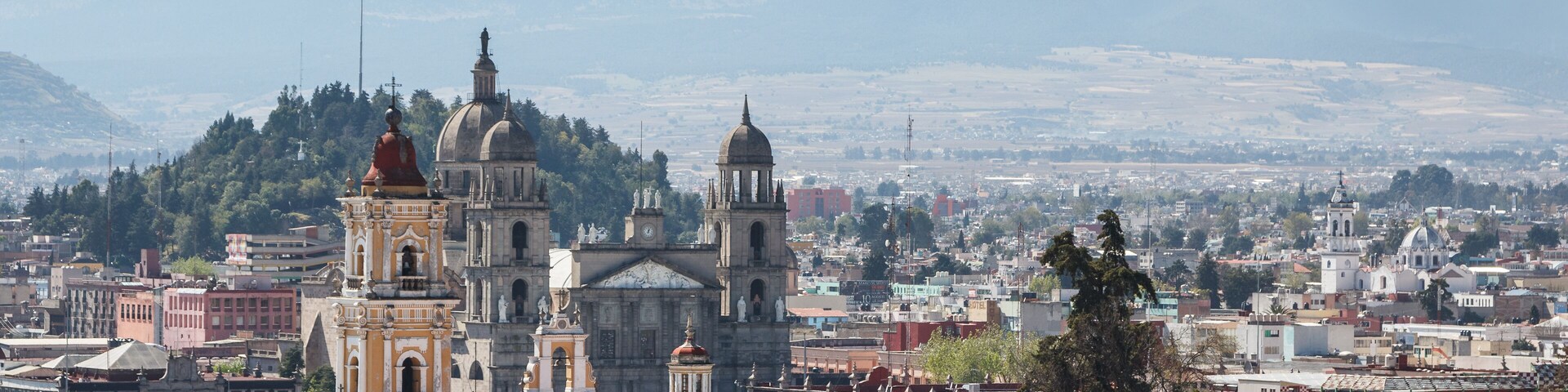 A cityscape with prominent historical buildings and a snow-capped mountain in the background.