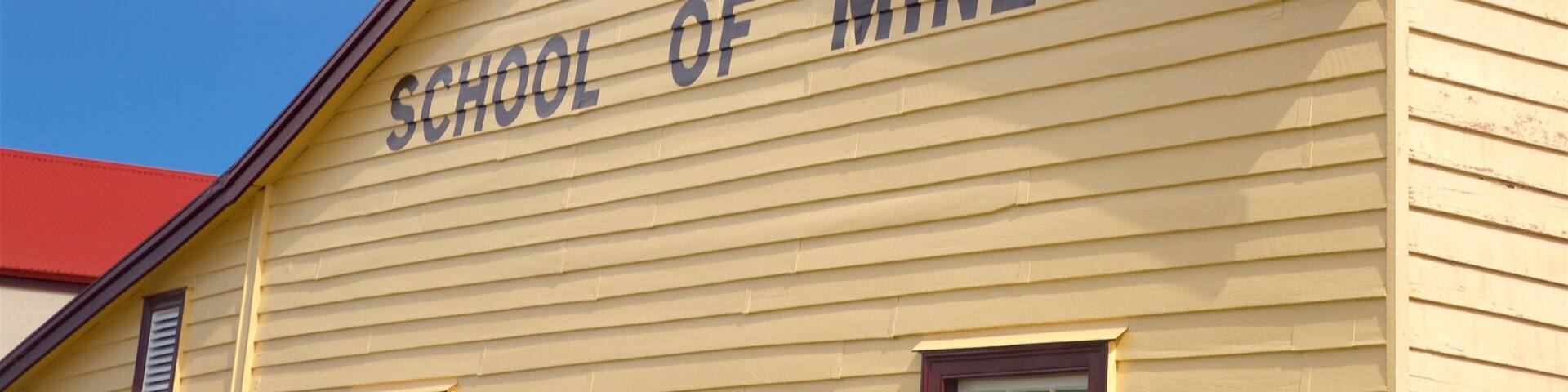 A building with the sign "Thames School of Mines."
