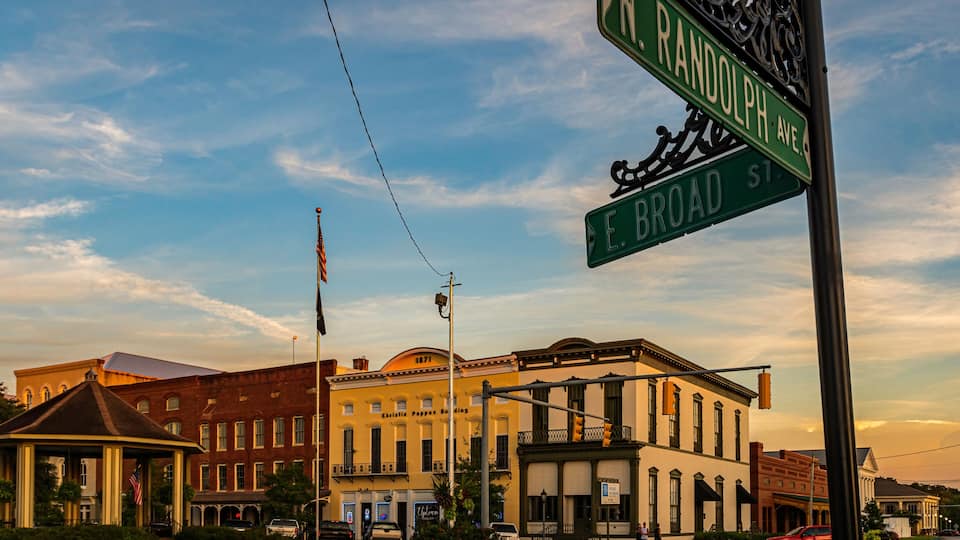 A street intersection with signs for N. Randolph Ave and E. Broad St.