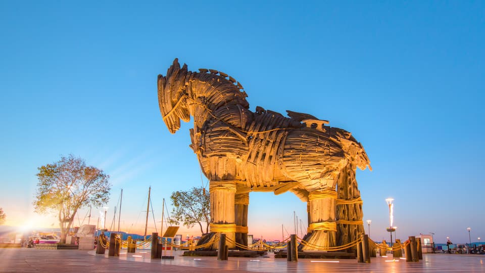 A large, illuminated sculpture of a horse in an open plaza.