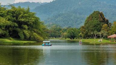 Un lago tranquilo con barcos, rodeado de exuberante vegetación y colinas.