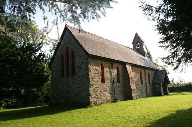 A stone church with a bell tower and arched windows.