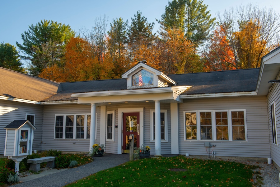 A house with a red door, white columns, and a small porch.