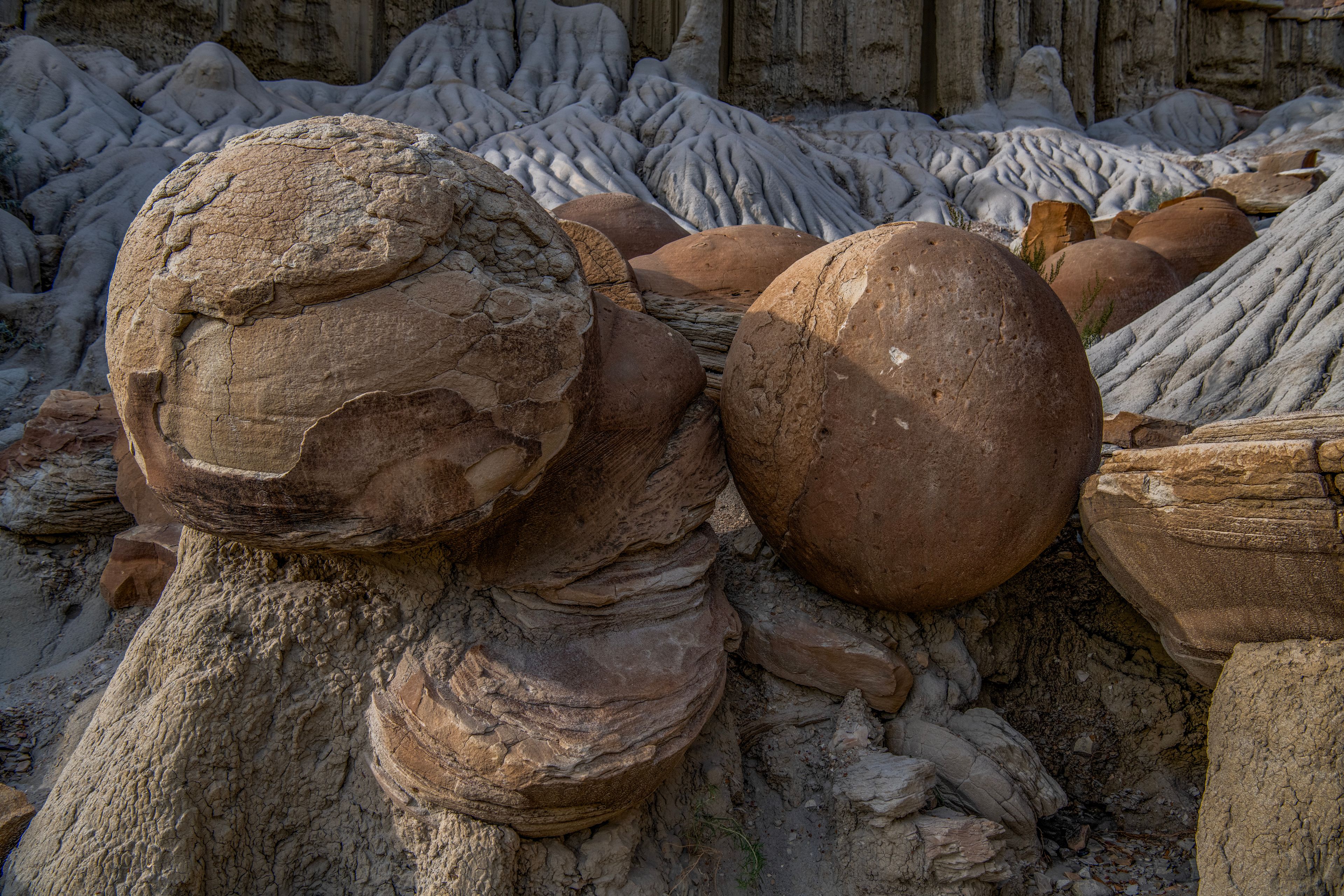 A collection of large, smooth boulders with a weathered surface, surrounded by smaller rocks and a rocky terrain.