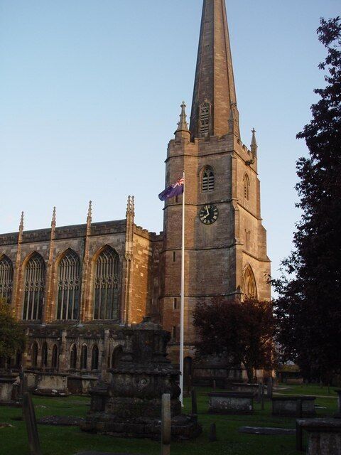 A historic church with a tall spire, large arched windows, and a clock tower.
