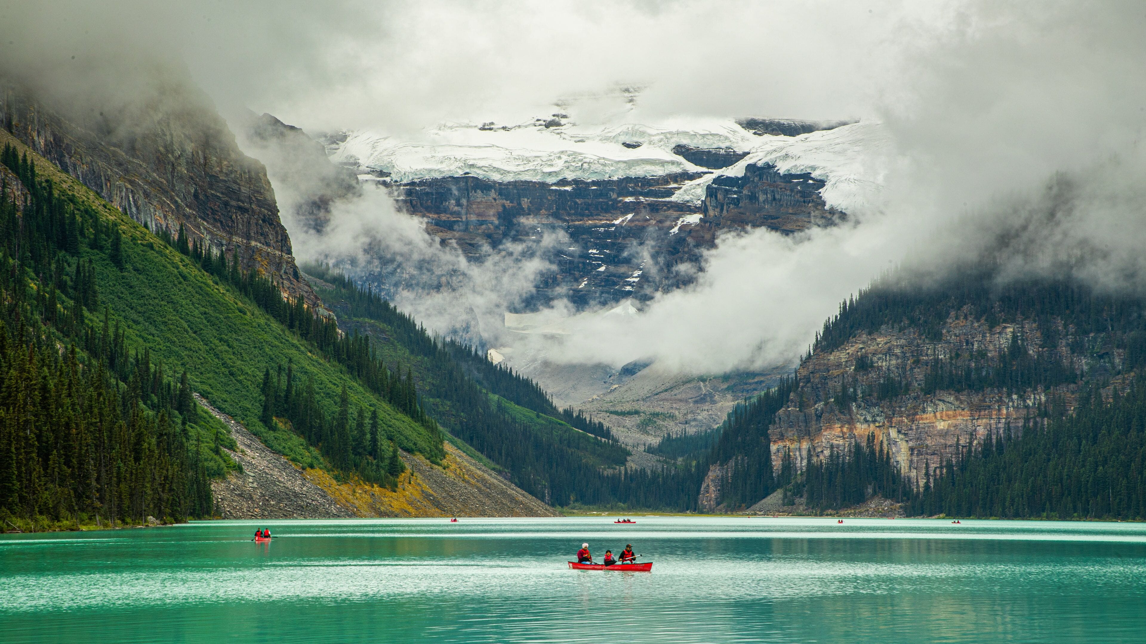 Lake Louise showing a lake or waterhole, boating and mist or fog