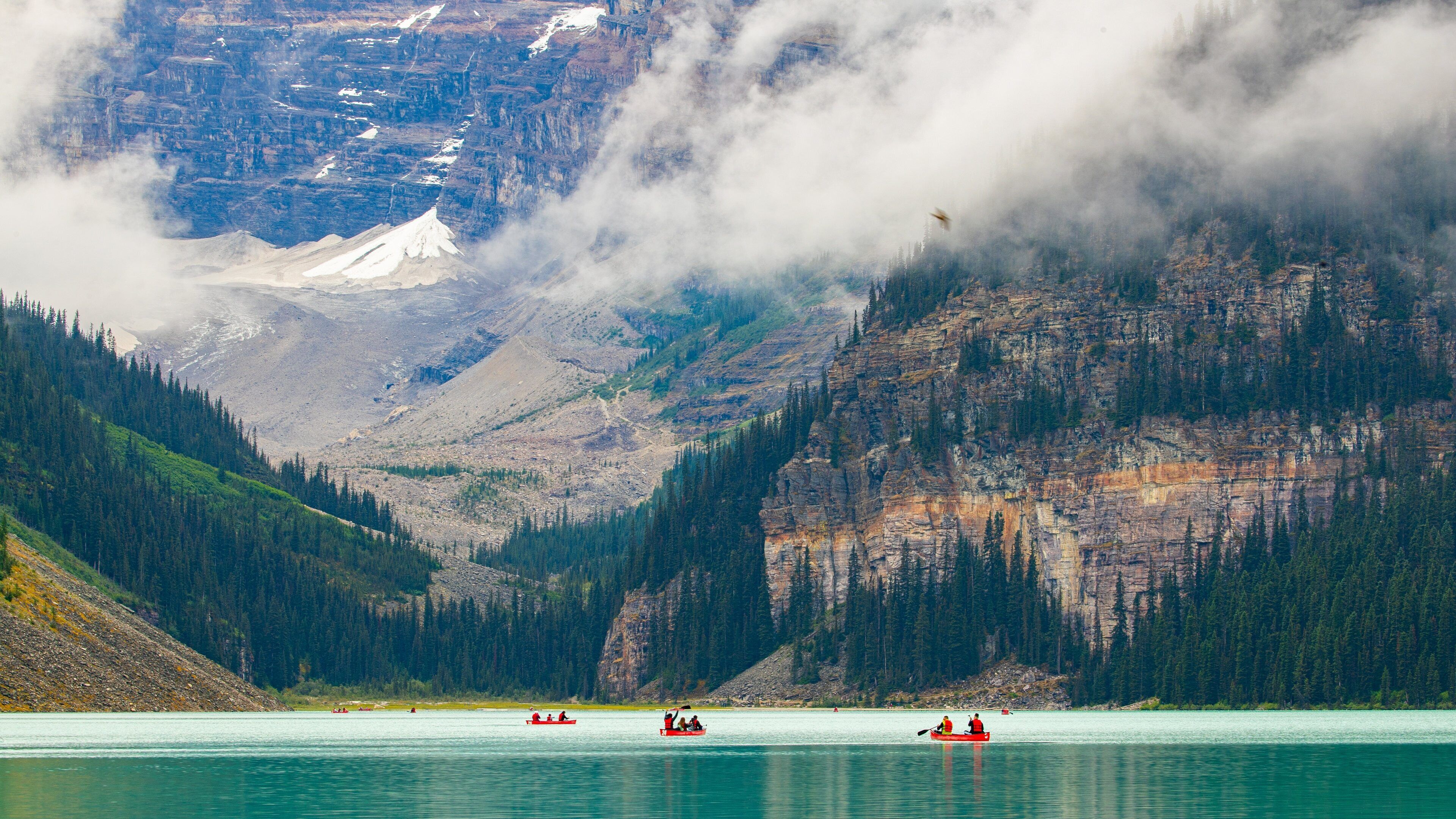 Lake Louise which includes mist or fog, mountains and boating