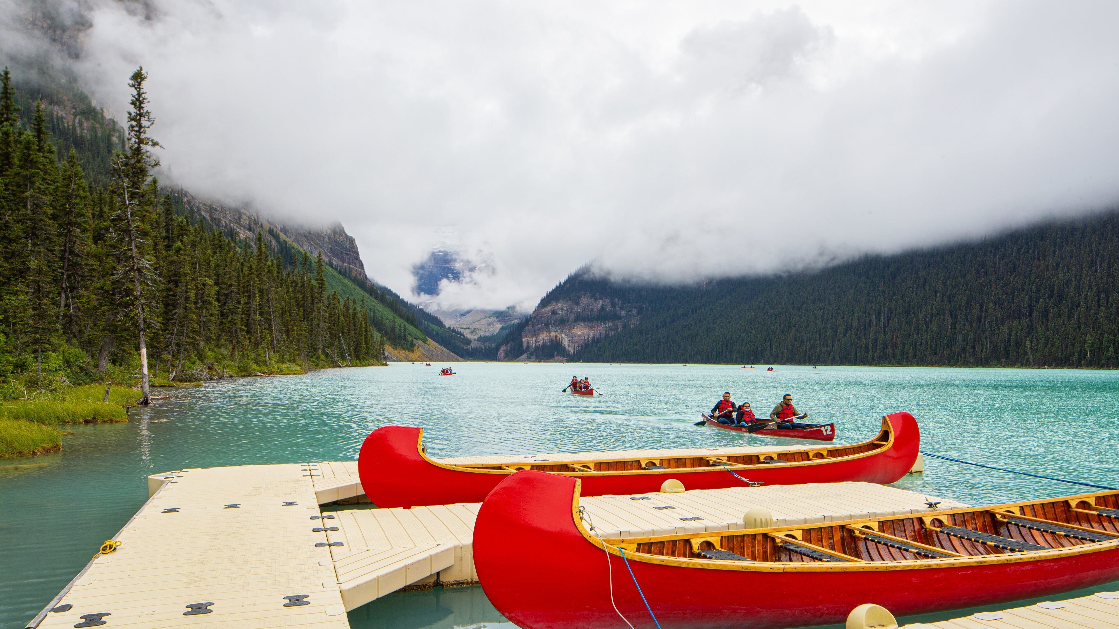 Lake Louise showing a lake or waterhole, mist or fog and boating