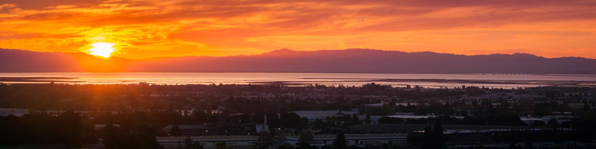 Sunset view of Hayward and Union City from Garin Dry Creek Pioneer Regional Park, east San Francisco bay shoreline and San Mateo bridge in the background, California