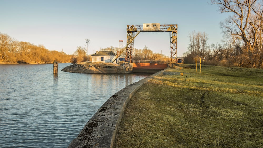 Une écluse sur une rivière, avec un petit bâtiment à proximité.