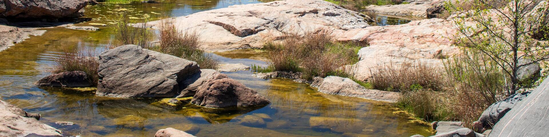 A stream known as Spring Creek flows over the sandstone formations on a beautiful spring day in the Texas Hill Country