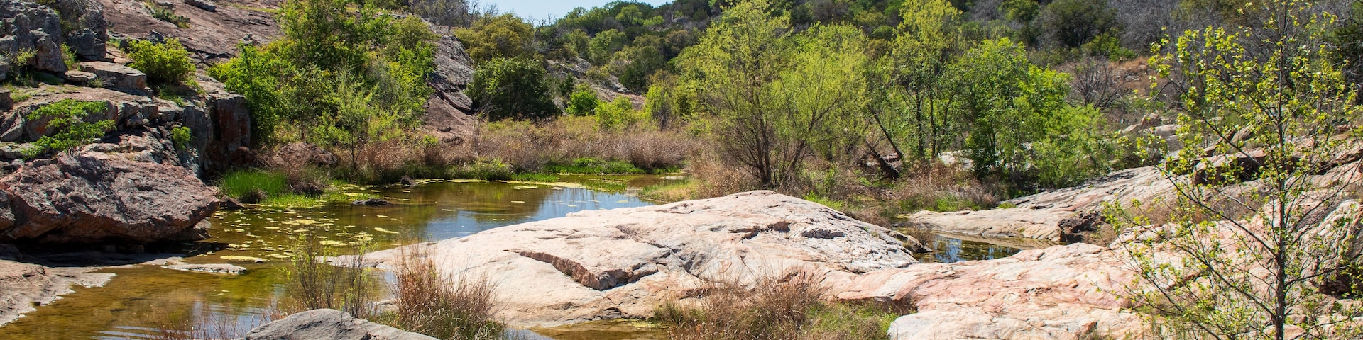 A stream known as Spring Creek flows over the sandstone formations on a beautiful spring day in the Texas Hill Country
