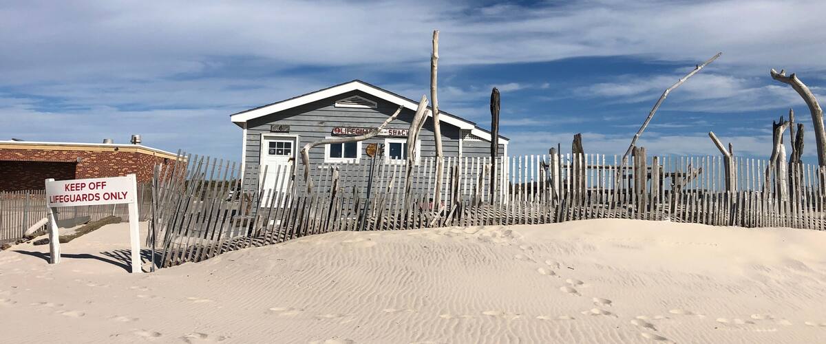 A lifeguard station with a wooden fence and a sign that reads 'KEEP OFF LIFEGUARDS ONLY.'