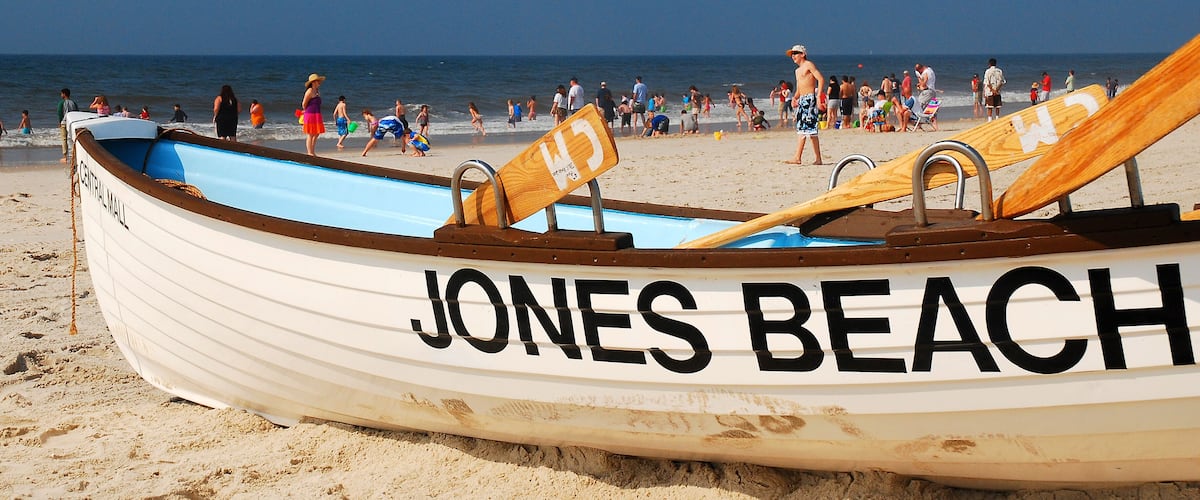 A beach with a rowboat labeled "JONES BEACH" and people walking along the shore.