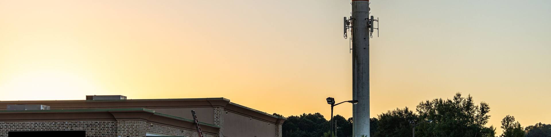Pooler, Georgia water tower in city near Savannah with dark dawn blue sky at sunrise with golden yellow light landscape view with nobody