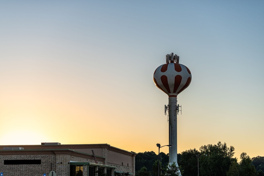 Pooler, Georgia water tower in city near Savannah with dark dawn blue sky at sunrise with golden yellow light landscape view with nobody