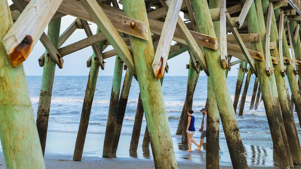 A wooden pier with people walking on it.