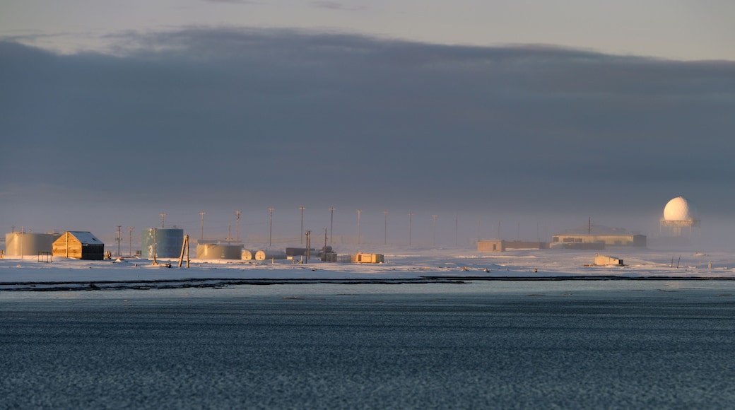 DEW line radar station and fuel tanks on Barter Island with fog over Kaktovik Alaska