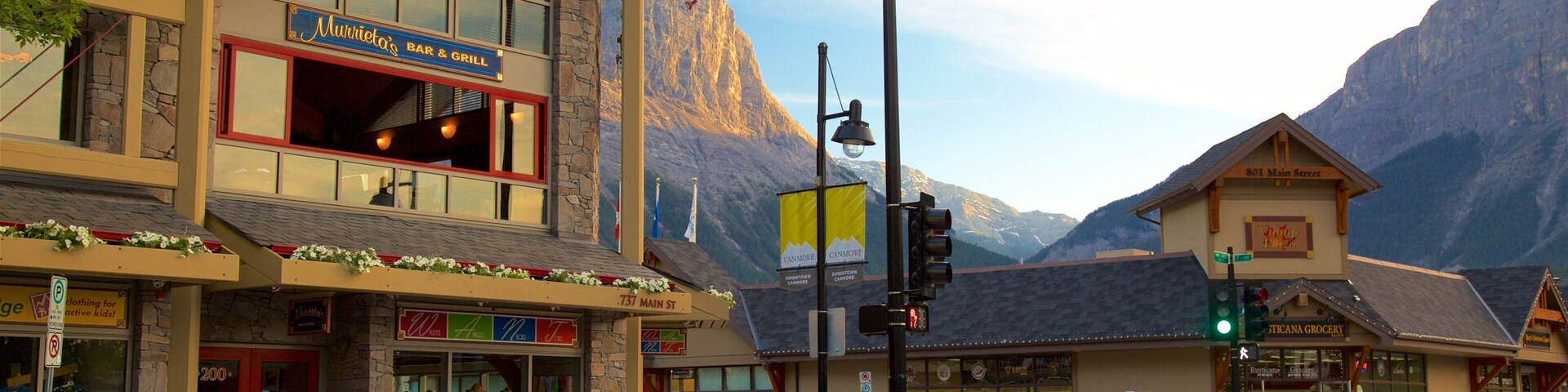 Uma cidade montanhosa com um bar e restaurante, um supermercado e montanhas ao fundo.
